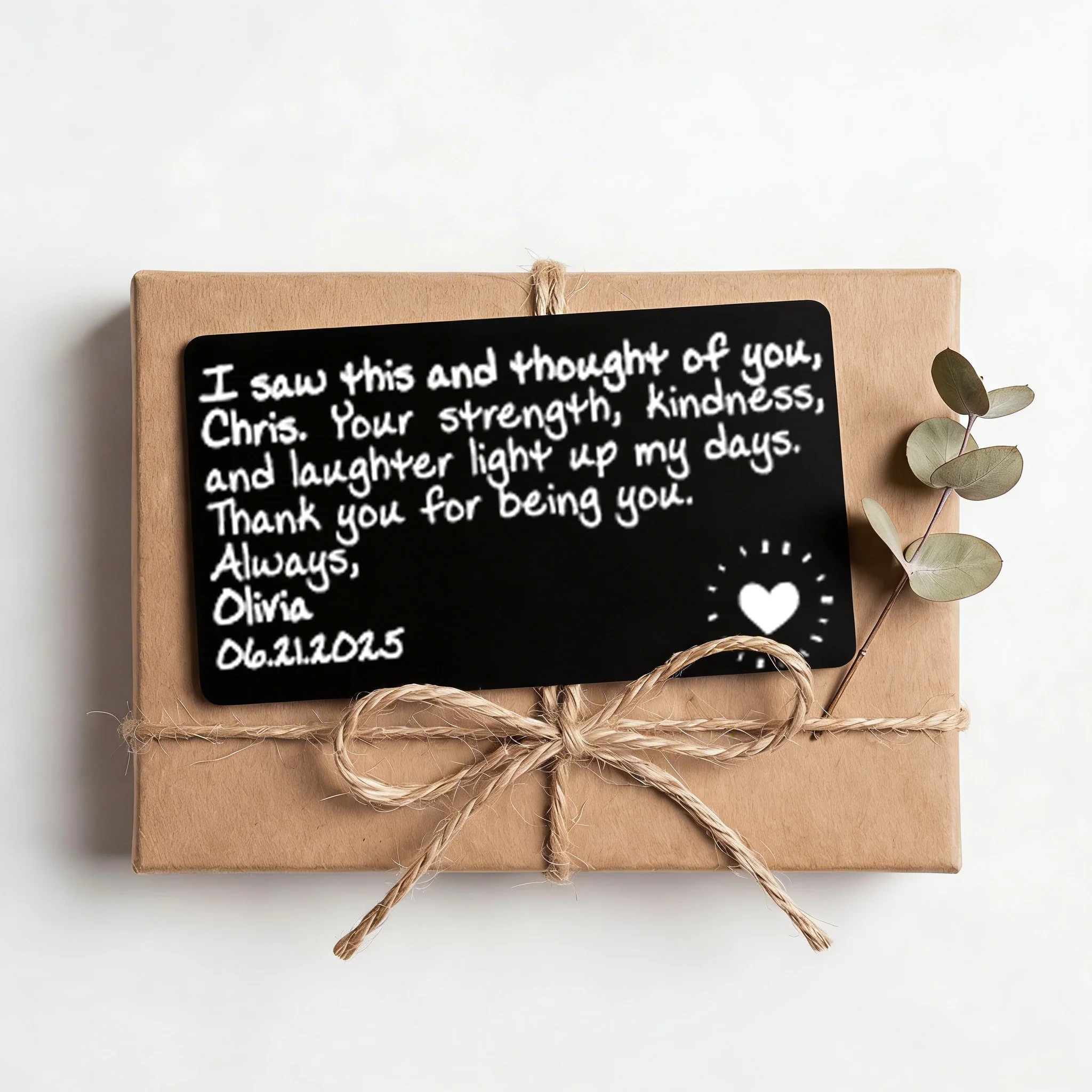 Custom engraved wallet card resting on a kraft gift box with twine bow